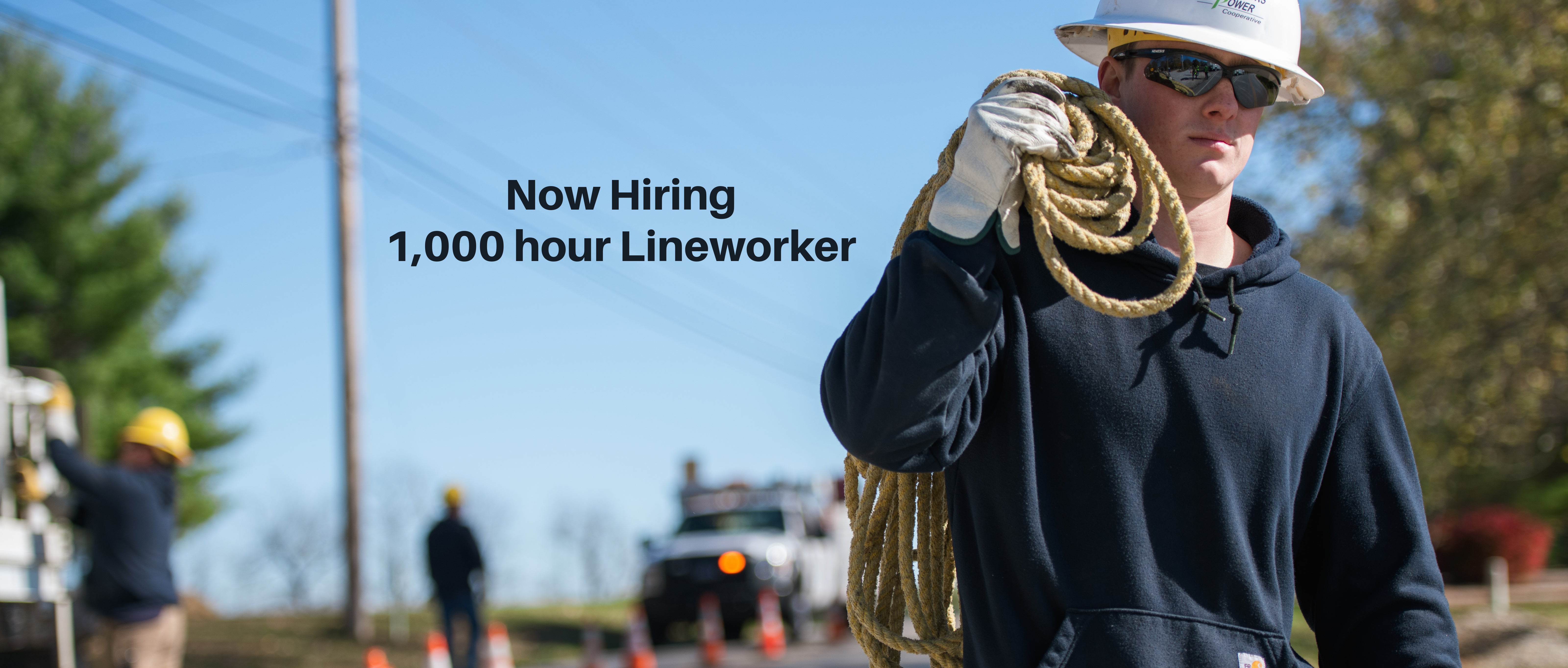Lineworker carrying a rope - "Now Hiring 1,000 hour Lineworker"