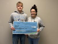 Cooper Palmer receiving large Scholar of the week check
