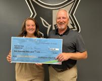 Emily Heuer receiving check from Gen Mgr Dave Eide