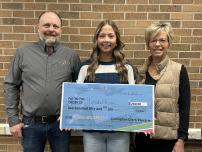 Hannah Heiman receiving large check from director Roy Gjerde