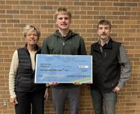 Lincoln Reidburn receiving large check from director Jay Foster